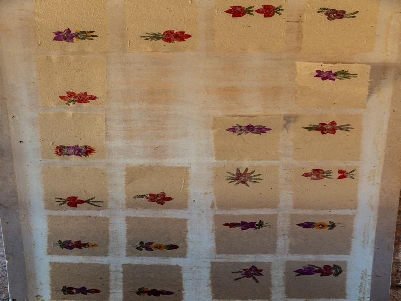 The make the paper from cooked tree bark and embed local flowers